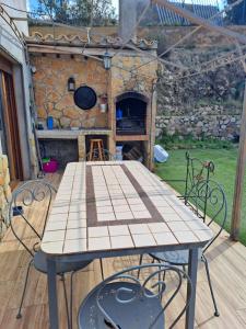 - une table et des chaises sur une terrasse avec un four en pierre dans l'établissement Villa Breda, piscina terraza privada, à Terra Brava