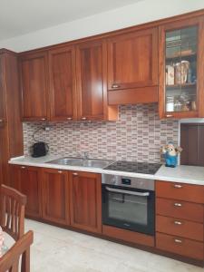 a kitchen with wooden cabinets and a stove top oven at Alba Mozzafiato in Lanusei