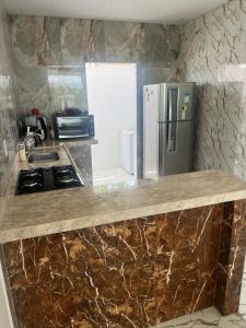 eine Küche mit einer Theke mit einem Herd und einem Kühlschrank in der Unterkunft Casa nova para alugar em Campina Grande toda mobiliada in Campina Grande