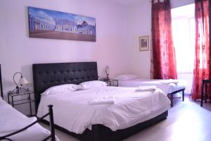 1 dormitorio con 2 camas con sábanas blancas en Candia41, en Roma
