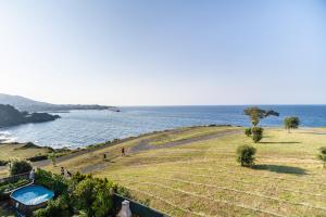 un champ avec une piscine à côté de l'océan dans l'établissement Chalet junto al mar, à Castro Urdiales