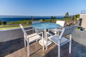 d'une table et de chaises en verre sur un balcon donnant sur l'océan. dans l'établissement Chalet junto al mar, à Castro Urdiales
