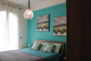 een slaapkamer met blauwe muren en een bed met kussens bij Casa Mirra in Peschiera del Garda
