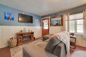 un soggiorno con un divano e una TV di Family-Friendly Cabin Walk to Lake Access! a Houghton Lake