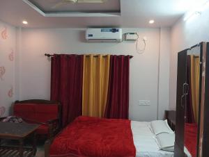 ein Schlafzimmer mit einem Bett, Vorhängen und einem Tisch in der Unterkunft Homestay Rooms& Food Sri Ranga Homestay in Belūr