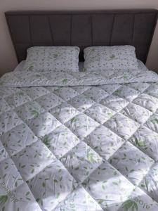 a bed with a white comforter and pillows at MyApartment in Chişinău