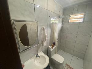 ein kleines Bad mit einem WC und einem Spiegel in der Unterkunft Casa de férias em Gravatá, Navegantes perto da praia in Navegantes + 6 Fotos
