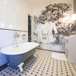 a bathroom with a bath tub and a wall mural at Les Suites BB, Champagne Besserat de Bellefon in Épernay