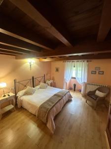 a bedroom with a large bed and a chair at Casa Rural Anxeliña in Boborás +39 photos