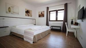 a bedroom with a bed and a desk and a television at Spacious House Near the Beach in San Pietro in San Pietro in Bevagna
