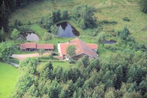 Vue aérienne d'une maison sur une colline avec deux réservoirs dans l'établissement Gites De La Racine, à Girmont-Val-d'Ajol
