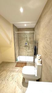 a bathroom with a toilet and a shower with a shower at St Leonards Boutique Apartment in Hollington +5 photos