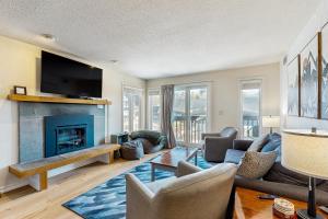 Una sala de estar con chimenea y televisión. en Okemo Mountain Lodge A208, en Ludlow