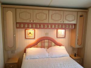 インゴールドメルズにあるGolden Sands Willerby GS 6 Berth Panel heated FREE WIFIの木製のヘッドボードが付いたベッドのある寝室