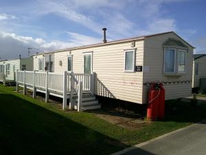 インゴールドメルズにあるGolden Sands Willerby GS 6 Berth Panel heated FREE WIFIの白いトレーラー(ポーチ付)と赤い消火器