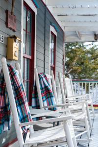 four rocking chairs sitting on the porch of a house at Downtown Primrose Piedmont House in Eureka Springs