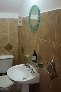 a bathroom with a sink and a toilet and a mirror at Casa Almendro-Chumamaya-Villa de Merlo in Country Club Chumamaya