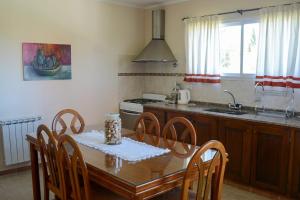 a kitchen with a wooden table with chairs and a sink at Casa Almendro-Chumamaya-Villa de Merlo in Country Club Chumamaya