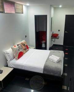 a bedroom with a bed and a bathroom with a toilet at Hotel Panorama Urban Medellin in Medellín