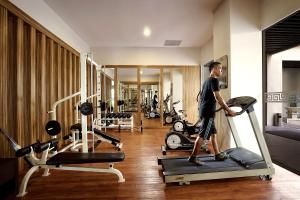 a man standing on a treadmill in a gym at Cavinton Hotel Malioboro Yogyakarta by Tritama Hospitality in Yogyakarta