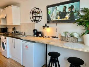 a kitchen with a counter with a tv on the wall at Studio Flat with Parking Off High St in Andover