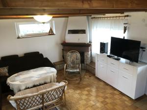 a living room with a couch and a television at Domek Spokojna Przystań in Przybrodzin