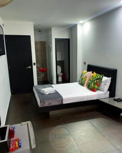 a bedroom with a large bed with pillows on it at Hotel Panorama Urban Medellin in Medellín +1 photo