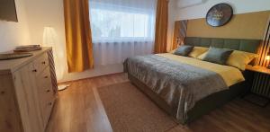 a bedroom with a bed and a dresser and a window at Privat Inn in Rakvice