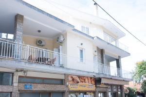 a white building with a balcony on top of it at Sunrise Apartment By Athens Airport in Spáta