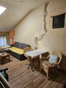 ein Wohnzimmer mit einer Couch und einem Tisch und Stühlen in der Unterkunft la petite maison in Céreste