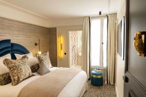 a bedroom with a large bed with a blue headboard at Hôtel l'Inattendu in Paris
