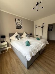 ein Schlafzimmer mit einem großen weißen Bett mit blauen Kissen in der Unterkunft Apartment 2 Chic Chamber in Hannover