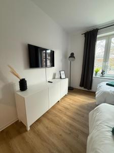 ein Schlafzimmer mit einer weißen Kommode und einem TV darauf in der Unterkunft Apartment 2 Chic Chamber in Hannover