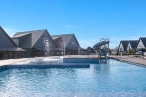 a large swimming pool with a water slide in front of houses at Over the Top in Hollister