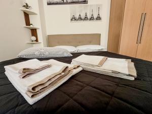 a bed with towels sitting on top of it at Smart Studio - Lingotto, Fiera & Metro in Turin
