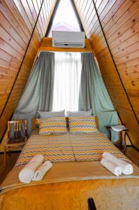 a bed in a tent with towels on it at A-Frame Kobuleti in K'obulet'i