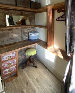 a room with a desk with a stool and a mirror at Lavender cottage in Gloucester
