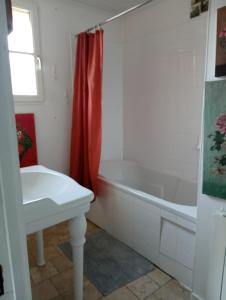 a bathroom with a white tub and a sink at Lulu in Castelmoron-sur-Lot