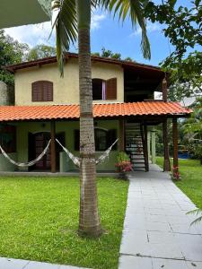 a house with a palm tree in front of it at Casa Calhetas Pousada I in São Sebastião