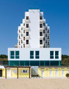 a building on the beach in front of a building at Hotel Alexander Museum Palace in Pesaro