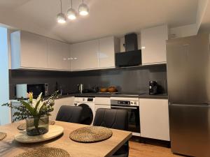 una cucina con mobili bianchi e un tavolo con sedie di Modern City Apartment in Anklam - Close to Center ad Anklam