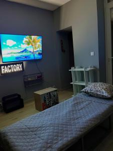 a bedroom with a bed and a flat screen tv at FactoryLoftCosy Gare à 5mins in Bellegarde-sur-Valserine