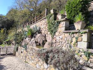 a stone retaining wall with stairs and plants on it at L'Ardéchois in Vals-les-Bains