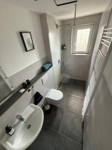 ein Badezimmer mit Waschbecken und Toilette in der Unterkunft Apartment 2 Chic Chamber in Hannover + 8 Fotos