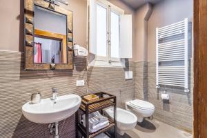 a bathroom with a sink and a toilet and a mirror at Vittorio's in Bari