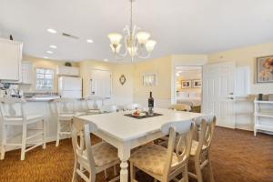 a kitchen and dining room with a white table and chairs at Lake Access Condo-Free Daily Tickets-Peaceful Views-Expansive in Kimberling City