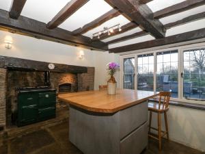 a kitchen with a counter and a fireplace at White Haywood Farmhouse in Hereford