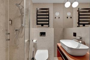 a bathroom with a sink and a toilet and a shower at Hotel Milo Gdansk Airport in Gdańsk +22 photos