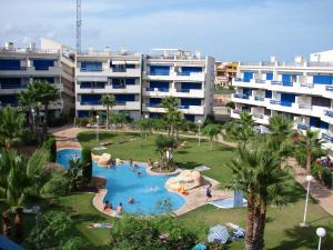 vista para uma piscina com pessoas num resort em Apartamento en La Calma em Playas de Orihuela