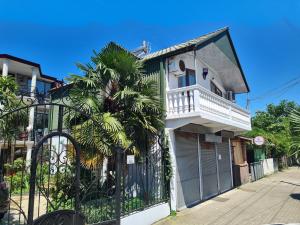 a building with a balcony and a palm tree at Guest House Rustaveli in K'obulet'i
